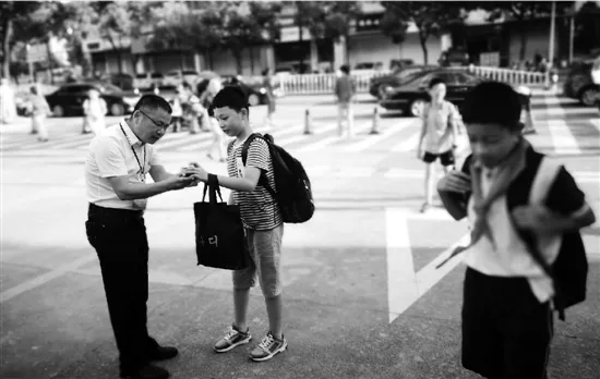 在校门口迎接学生,这位小学校长做了9年,他说会一直站下去